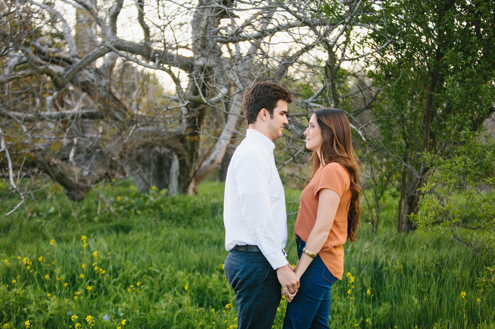 The couple standing in front of trees. 