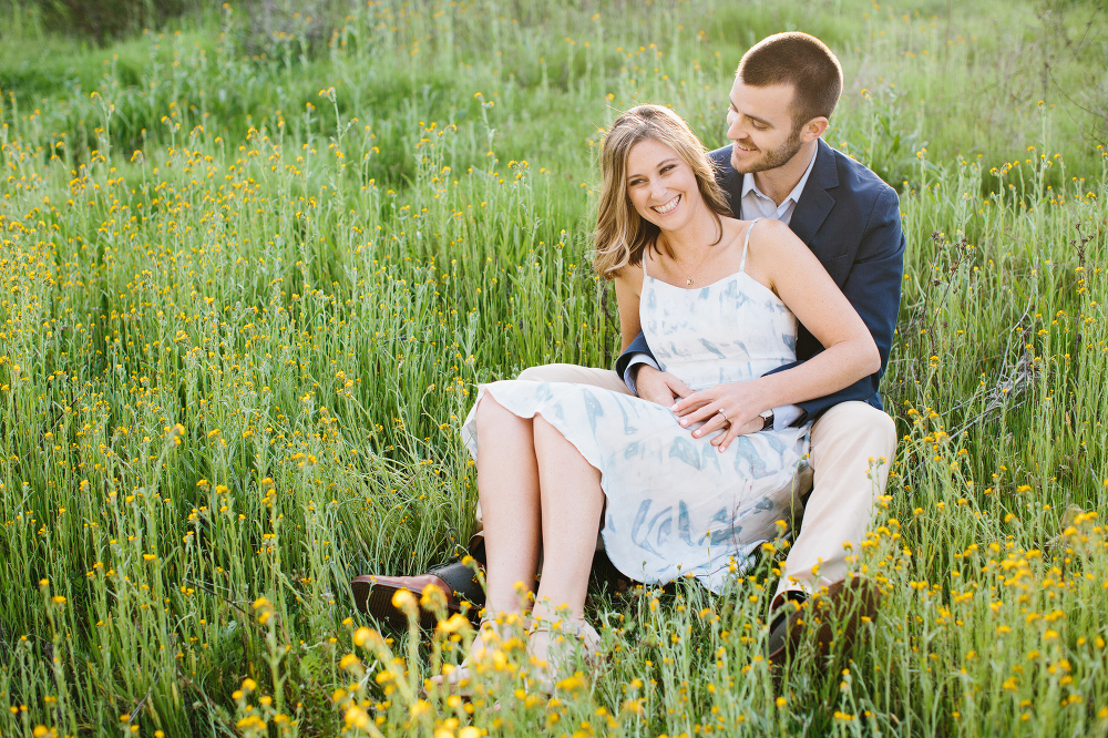 Kara and Sean sitting in a grass field. 