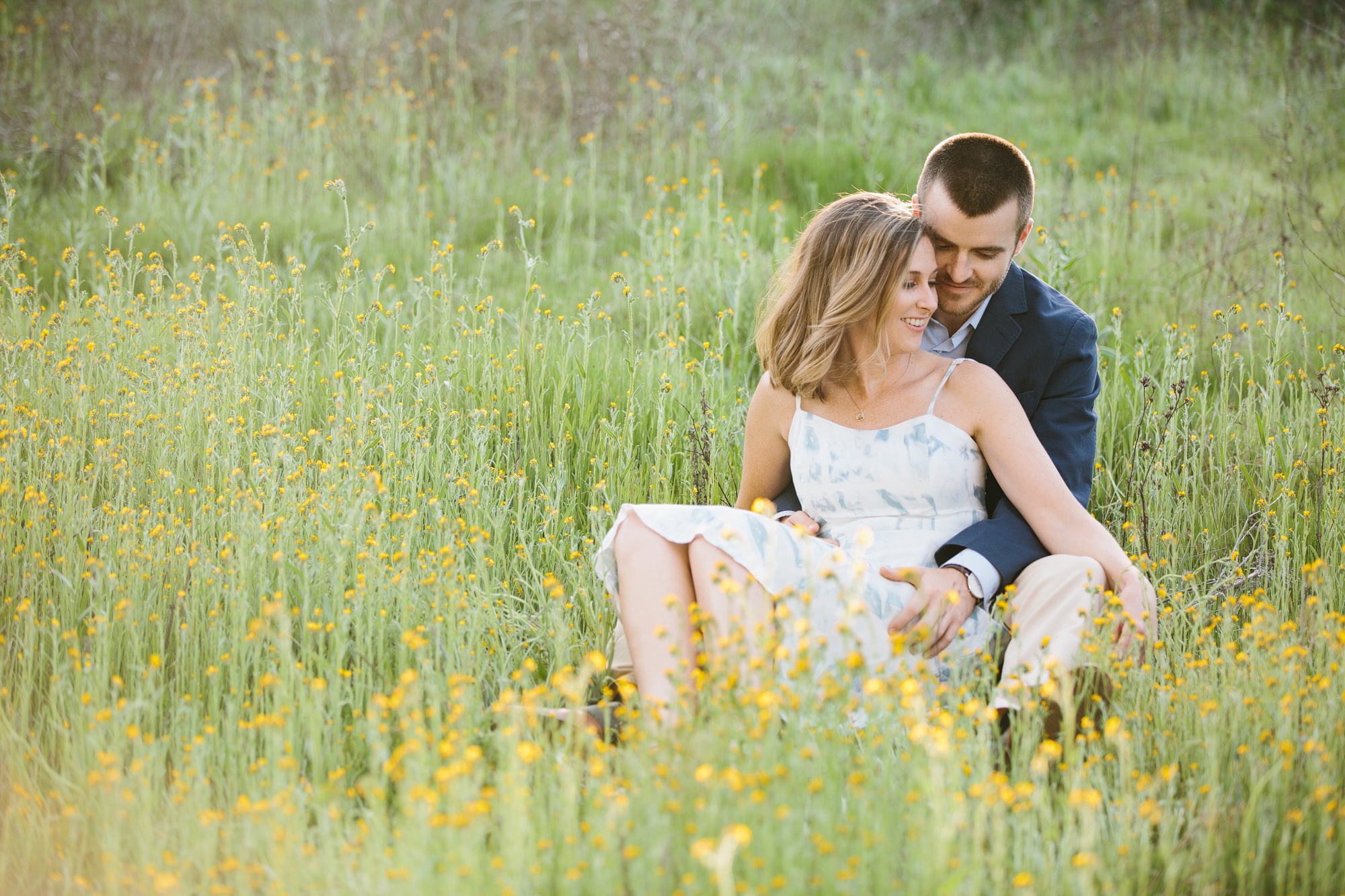 The couple in a field of yellow flowers. 