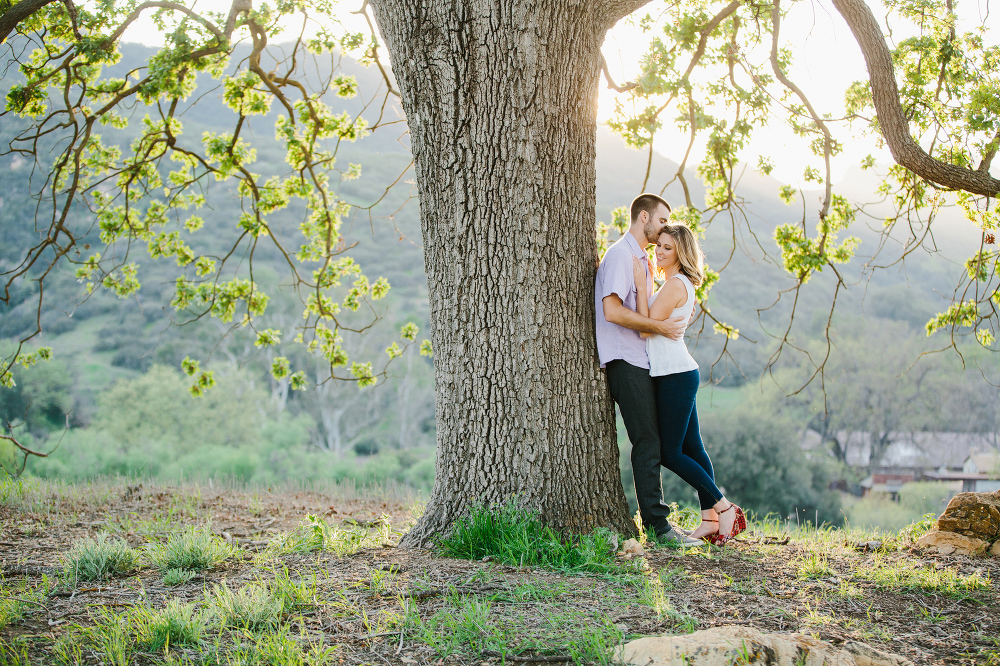 Kara and Sean leaning on a tree. 