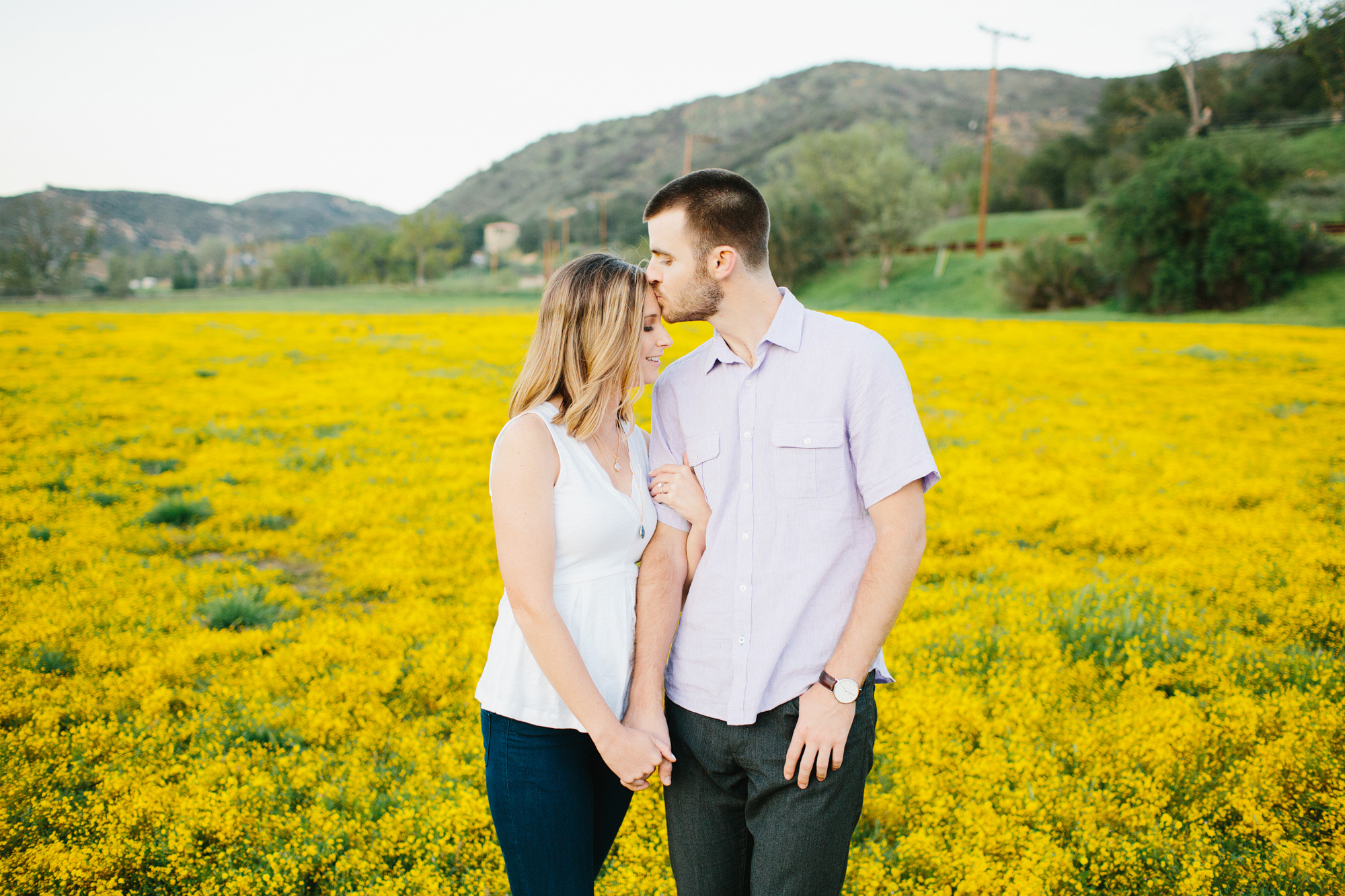 The couple surrounded by yellow flowers. 