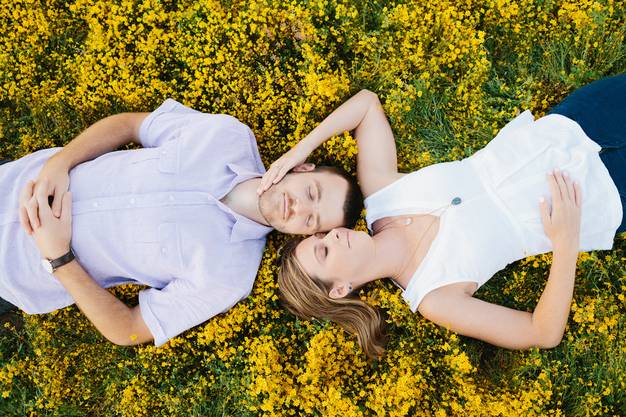 The couple laying in the yellow fields. 